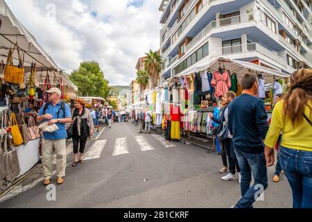 I turisti e gli italiani locali fanno shopping nella città mediterranea di Ventimiglia, in Italia, sulla Riviera Italiana, nel mercato delle pulci e dell'abbigliamento da venerdì. Foto Stock