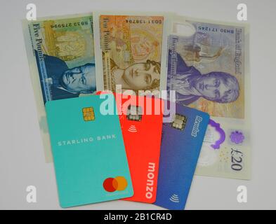 Starling, Monzo, carte bancarie Revolut sulle nuove banconote in sterline. Concetto per evidenziare gamma di colori simili delle fatture e della banca britanniche. Foto Stock