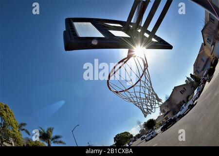 Rete di pallacanestro al sole su una strada Foto Stock