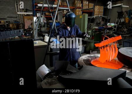 Processo di rinvenimento in fabbrica di coltelli. Forno, bagno d'olio e scarico Foto Stock