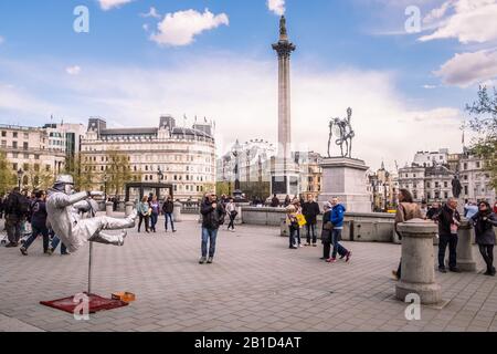 Turisti e artisti di strada a Trafalgar Square nella città di Westminster, Regno Unito Foto Stock