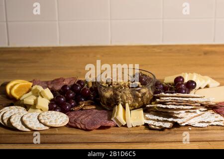 Piatto di cibo a bordo di salumi su vassoio di servizio in legno Rustico mediterraneo gourmet cibo con salumi e assortimento di formaggi. Mangiare cibo delizioso. Foto Stock