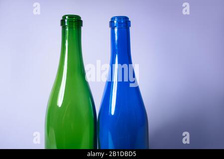 L'immagine mostra due bottiglie, verdi e blu, davanti a uno sfondo bianco. Foto Stock
