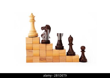 Pezzi di chee su un edificio scala con blocchi di legno isolati con bianco, gerarchia metafore, classifica, lavoro di squadra e strategia nel concetto di business Foto Stock