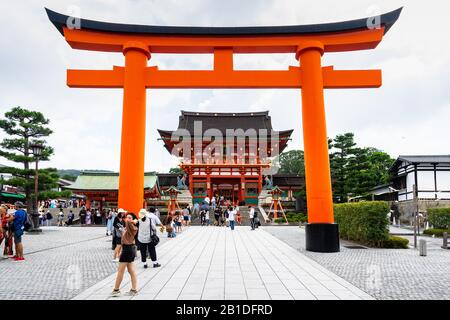 Kyoto, Giappone, 16 agosto 2019 – porta dei torii arancioni giganti di fronte alla porta Romon all'ingresso di Fushimi Inari, il santuario più famoso di Kyoto Foto Stock