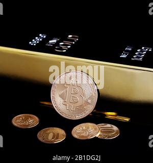 Bitcoin cryptocurrency e barra color oro su sfondo nero Foto Stock