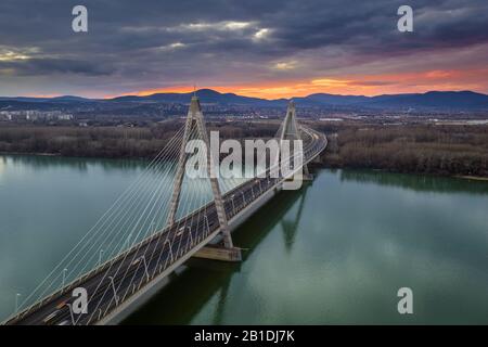 Budapest, Ungheria - Ponte Megyeri sul Danubio al tramonto con traffico pesante e cielo e nuvole belle Foto Stock