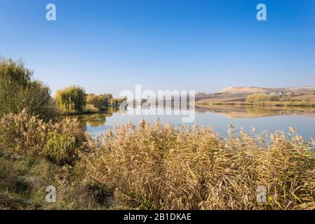 Bellissimo paesaggio di lago e colline sotto un cielo blu Foto Stock