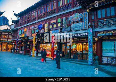 L'area normalmente vivace di fronte allo Starbucks in Yuyuan, una popolare destinazione turistica in Shanghai. Molti negozi sono chiusi e solo poche persone Foto Stock