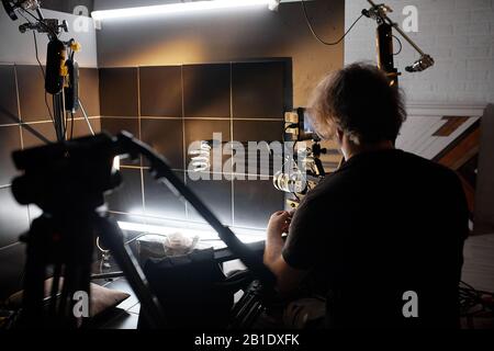 Backstage di produzione video. Dietro le quinte di creare contenuti video, un team professionale di cameramen con un regista filmare annunci commerciali. Vide Foto Stock