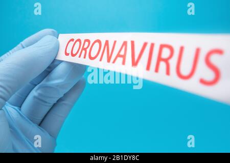 Malattia di coronavirus 2019. Il guanto per uso medico può contenere un foglio di carta con il coronavirus stampato su di esso. Covid-19 - Il Romanzo di Wuhan Coronavirus polmonite: COVID-19. Virus pericoloso, batteri. Foto Stock