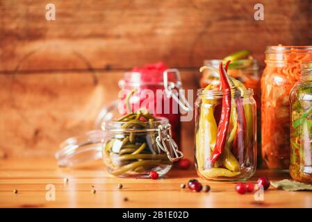 Background alimentare probiotici. Carote, kimchi, barbabietole, crauti, cetrioli sottaceto in vasi di vetro. Concetto di cibo fermentato e inscatolante invernale. Banner con spazio di copia. Foto Stock