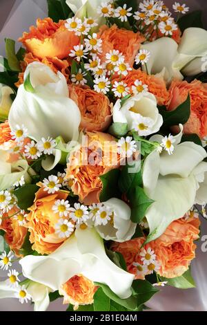 Primo piano di moda bouquet moderno di fiori diversi su sfondo di legno. Masterclass. Regalo per sposa in matrimonio, madre, donna. Romantica moda primaverile. Colori luminosi di sentimenti. Foto Stock