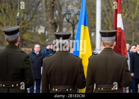 Riga, Lettonia. 25th Feb, 2020. Guardie onorarie con bandiere di Ucraina e Lettonia, durante la cerimonia di posa dei fiori al Monumento della libertà a riga, Lettonia. Credito: Gints Ivuskans/Alamy Live News Foto Stock