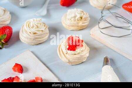 Fragola PavlovaHomemade piccola fragola pavlova meringa torte alla crema dessert con menta fresca Foto Stock