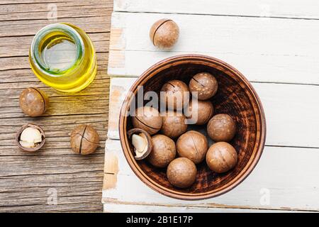 Bottiglia di olio di noce macadamia e noci di macadamia Foto Stock