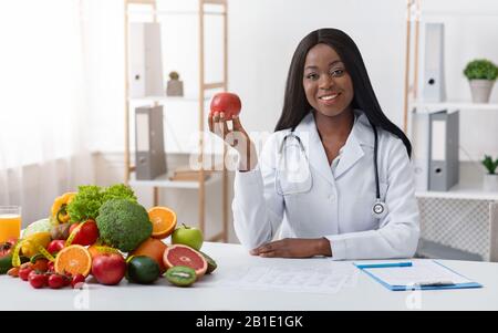 Bellissimo medico dietologo che tiene la mela in mano Foto Stock