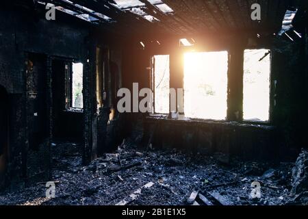 Gli interni bruciati della casa dopo il fuoco. Muri di legno bruciati Foto Stock