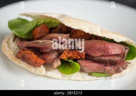 Pane Woodpigeon e chorizo pitta. Il filetto di piccione è stato fritto con il flash per lasciarlo tenero, affettato e poi messo nel pane pitta con choriz fritto Foto Stock