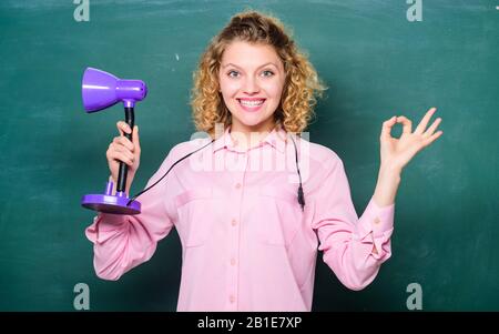 Idea educativa. Giornata della conoscenza. Concetto di illuminazione. Creatività e ispirazione. Illumina il processo di studio. Intuizione e idea. Teacher Hold tavolo lampada lavagna sfondo. Brillante idea brillante. Foto Stock