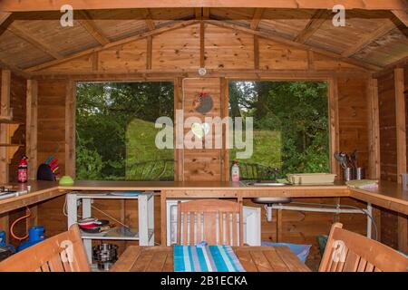 Galles, Regno Unito: 10 ago 2016 : campeggio di lusso o alloggio glamping, con una cucina esterna riparata - patio - cena, ritorno alla natura al ritiro di Seren, Foto Stock