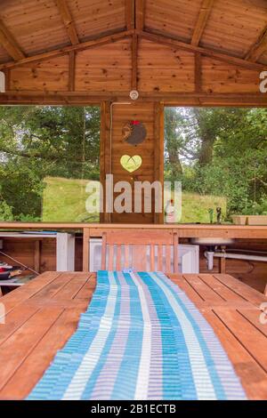 Galles, Regno Unito: 10 ago 2016 : campeggio di lusso o alloggio glamping, con una cucina esterna riparata - patio - cena, ritorno alla natura al ritiro di Seren, Foto Stock