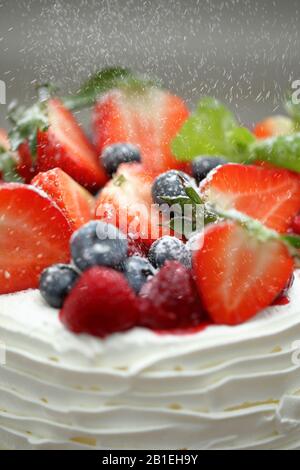 Decorazione di frutta su una torta di nozze cosparsa di zucchero a velo Foto Stock