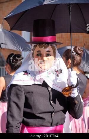 Cucciolata di Huehues in costumi tradizionali messicani al Carnevale di Tlaxcala. Ritratto di un ballerino maschile Catrines che tiene un ombrello Tlaxcala, Messico, Foto Stock