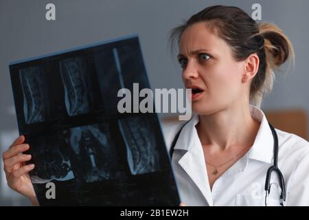 Terapista che considera i raggi X. Foto Stock