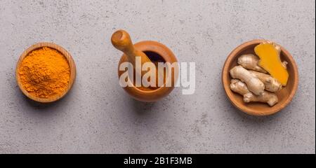 Radice spellata e polvere curcuma in ciotole di legno Foto Stock