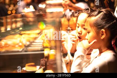 Shanghai, CINA - 11 GENNAIO 2020: La ragazza aspecifica vorrebbe mangiare il pane al Roastero Starbucks di Shanghai è il più grande Starbucks del mondo. Foto Stock