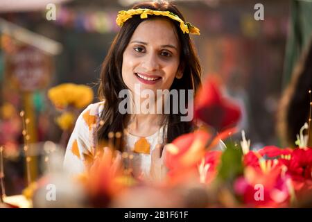 Donne che cercano sulla tiara floreale al mercato della strada Foto Stock