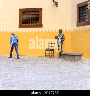 Donna cammina oltre la Statua di Nestor Alamo, compositore e scrittore spagnolo, Vegueta centro storico quartiere, Las Palmas de Gran Canaria, Isole Canarie, Spagna Foto Stock