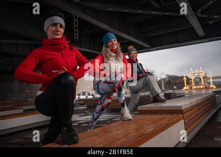 Donne Sane Di Mezza Età Che Si Scalano E Allungano Le Gambe All'Aperto. Stile Di Vita Attivo Delle Donne Mature. Eleganti Donne Che Esercitano Su Urban Background. Foto Stock