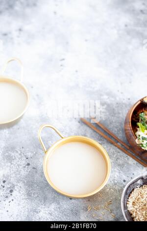 Il vino di riso Makgeolli è una delle più antiche bevande alcoliche tradizionali coreane fermentate. Bevanda sana asiatica. Orientamento verticale, vista dall'alto Foto Stock