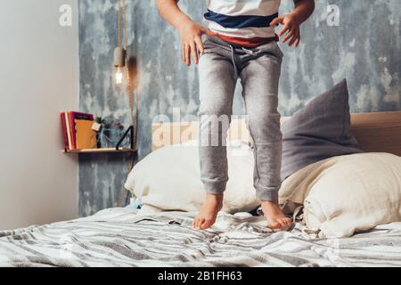 dettaglio di una piccola ragazza gambe saltando sul letto dei genitori, concetto di stile di vita di casa e infanzia felice Foto Stock