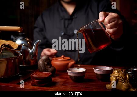 Cerimonia del tè. Un giovane uomo versa il tè da un teapot. Foto Stock