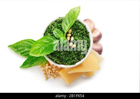 Salsa di pesto isolata su fondo bianco con ingredienti per la cottura del pesto. Set di prodotti tradizionale pesto di salsa italiana. Basilico, aglio Foto Stock