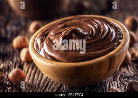 Cioccolato nocciola sparso in ciotola di legno - primo piano. Foto Stock