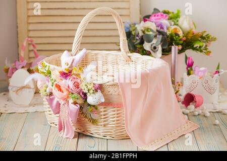 Cesto in vimini decorato con fiori e lacci Foto Stock