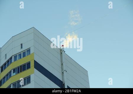 Caldaia sala fumo tubo collegato alla parete di un pannello moderno casa contro un cielo blu chiaro. Stock foto per web e stampa con spazio vuoto per testo e design. Foto Stock