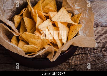 Tortilla patatine in ciotola artigianale su rustico tavolo di legno, primo piano Foto Stock