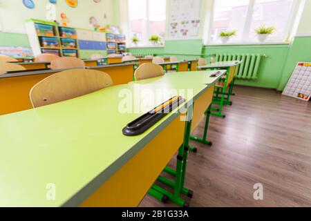 Scrivanie e sedie ad ampio angolo in classe. Foto Stock