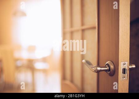 Porta con maniglia cromata in camera. Foto Stock