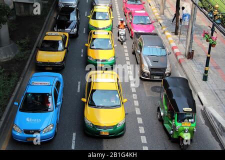 Taxi, tuk tuk e moto taxi su una strada trafficata Bangkok Foto Stock