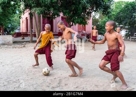 Monaci novizi che giocano a calcio presso il monastero buddista, Mingun, regione di Mandalay, Myanmar Foto Stock