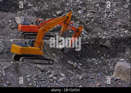 Due escavatori che scavano insieme il terreno Foto Stock