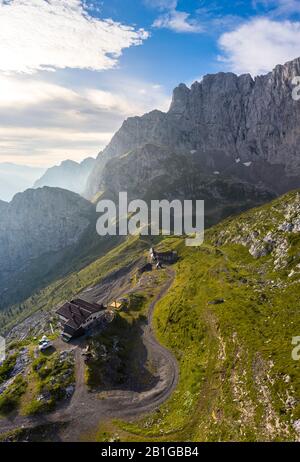 Veduta aerea delle vecchie capanne dei minatori e della parete nord della Presolana all'alba. Foto Stock