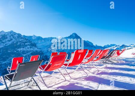 Grindelwald-FIRST, SVIZZERA - 15 GENNAIO 2020: Sedie a sdraio rosse vuote a Schreckfeld sulla Prima montagna Foto Stock