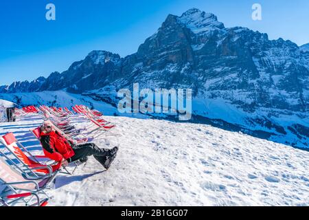 Grindelwald-FIRST, SVIZZERA - 15 GENNAIO 2020: Uno sciatore a Schreckfeld sulla Prima montagna ammira le splendide viste alpine Foto Stock